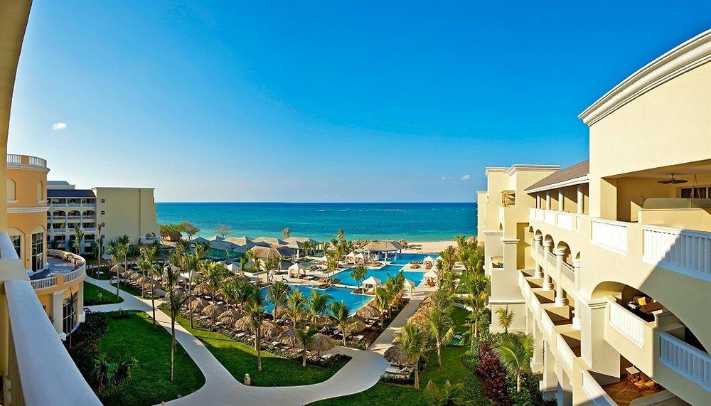 Aussicht auf das Iberostar Grand Rose Hall Hotel mit Pool und Meer im Hintergrund.