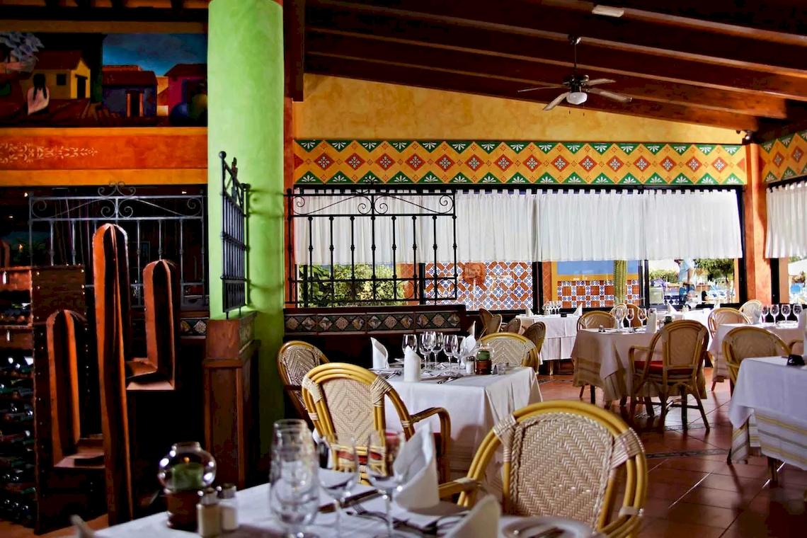 Innenansicht des Restaurants im Bahia Principe Sunlight Costa Adeje Hotel mit gedeckten Tischen und bunten Wänden.