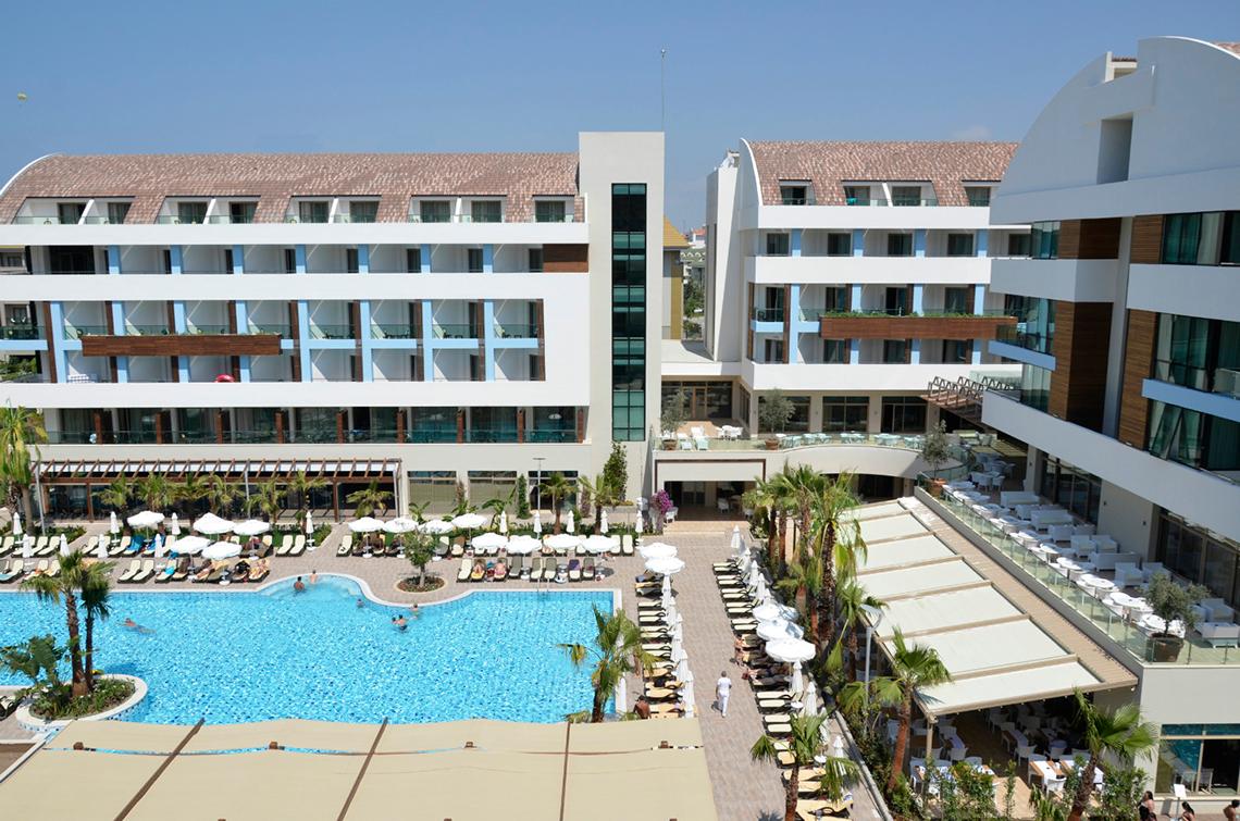 Luftaufnahme des Port Side Resort Hotels mit Swimmingpool und Sonnenliegen.