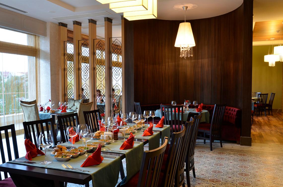 Innenansicht des Restaurants im Port Side Resort mit gedeckten Tischen und hängenden Kronleuchtern.