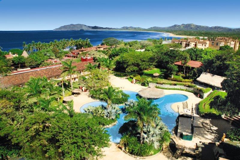 Luftaufnahme des Tamarindo Diria Beach Resorts mit Pool und Meer im Hintergrund.
