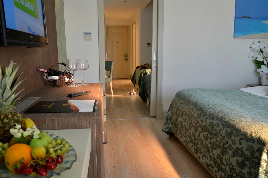 Ein Hotelzimmer mit einem Bett, einem Tisch und einer Flasche Wein.