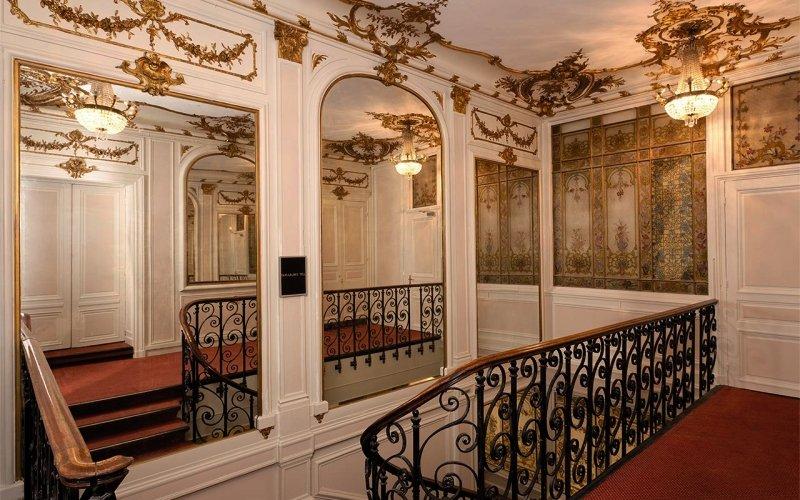 Innenbereich des Best Western Hotel Ronceray Opera mit gemusterten Wänden, Spiegeln und einer Treppe.