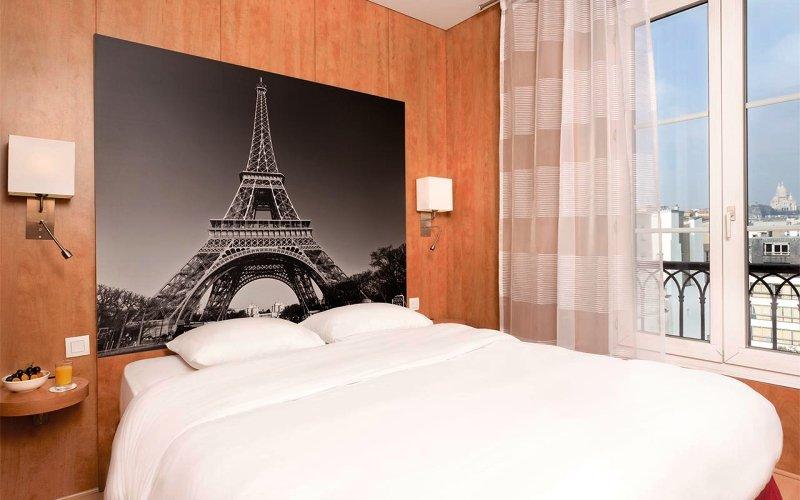 Ein elegantes Zimmer im Best Western Hotel Ronceray Opera mit Blick auf die Eiffelturm-Wand und ein Fenster.
