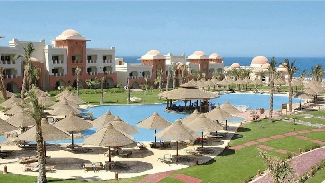 Luftaufnahme des Serenity Alpha Beach Resorts mit Swimmingpool, Sonnenschirmen und Hotelgebäuden am Meer
