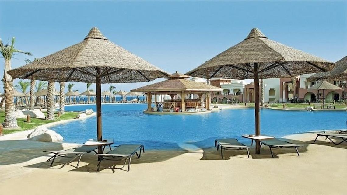 Außenpool im Serenity Alpha Beach Hotel mit Sonnenliegen und Sonnenschirmen.
