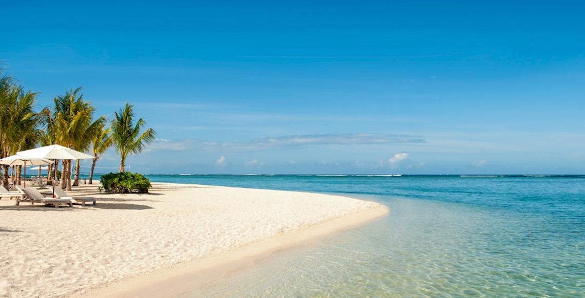 Strand des JW Marriott Mauritius Resorts mit weißen Liegestühlen und Schirmen