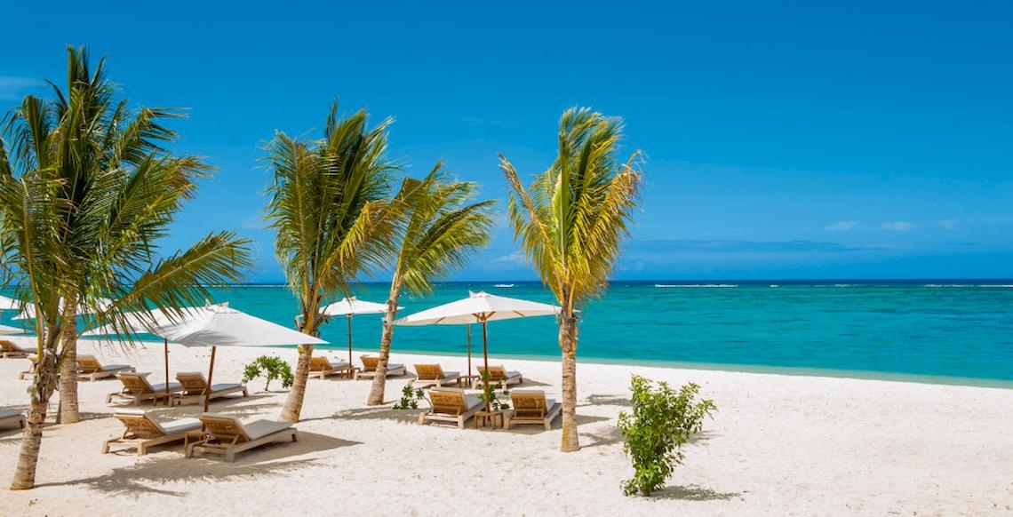 JW Marriott Mauritius Resort Strand mit weißen Sonnenschirmen und Liegen