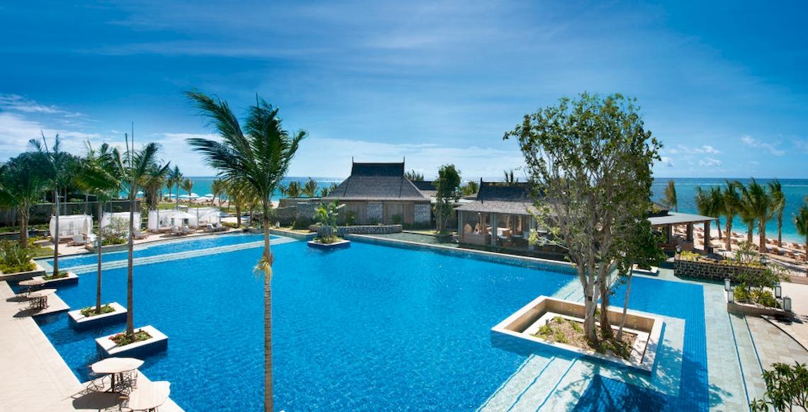 Außenbereich des JW Marriott Mauritius Resort mit Swimmingpool, Palmen und Strand