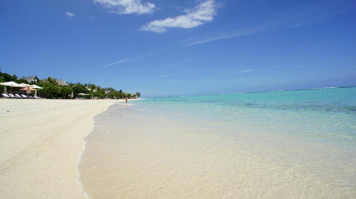 Strand des JW Marriott Mauritius Resorts mit weißem Sand und blauem Wasser