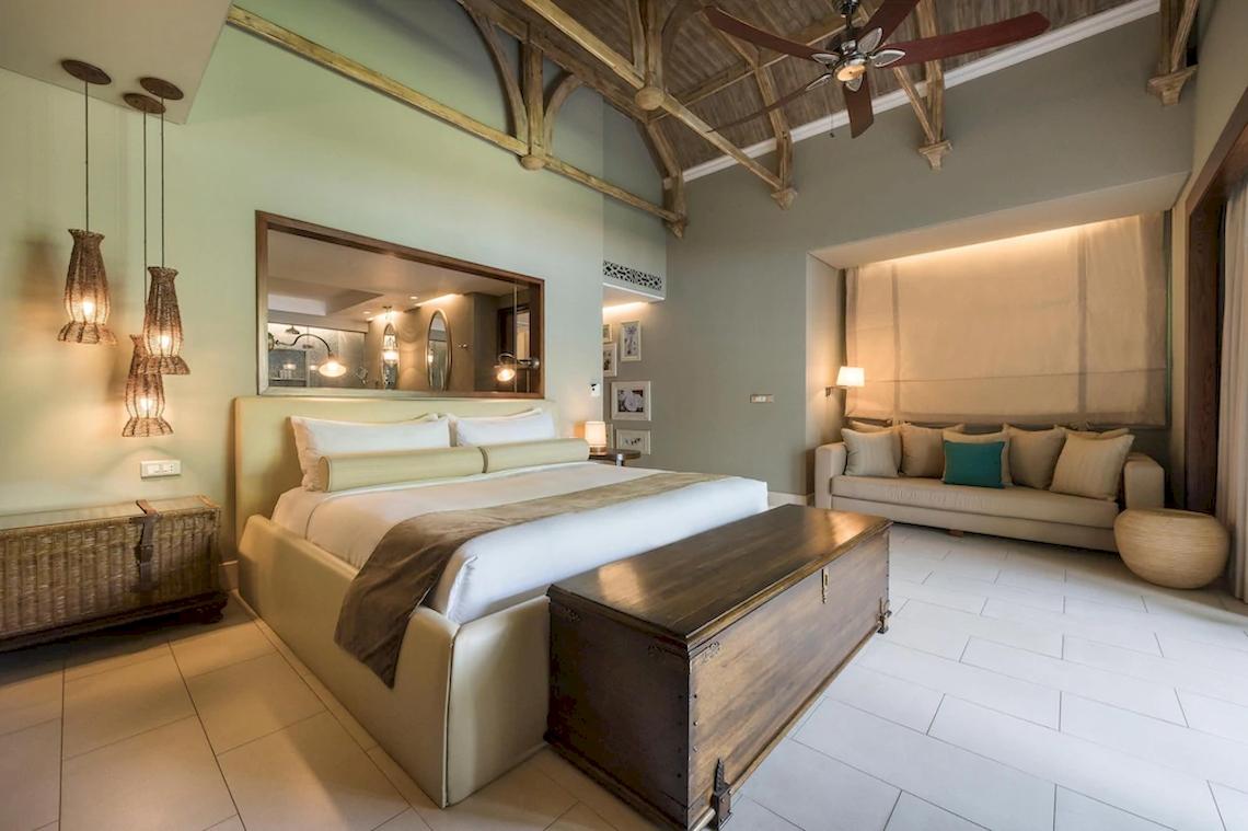 JW Marriott Mauritius Resort Hotelzimmer mit Bett, Sofa, Deckenventilator und Lampen.