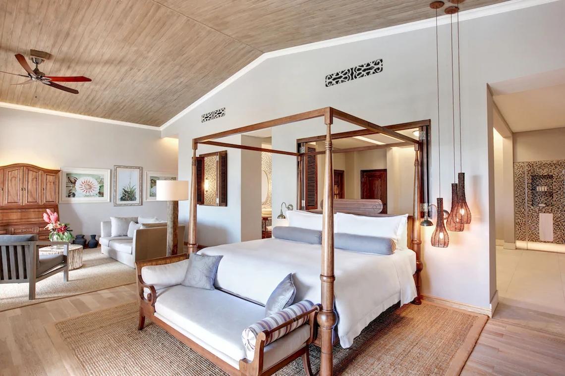 Schlafzimmer im JW Marriott Mauritius Resort mit vier Poster-Bett, Sofa und Deckenventilator