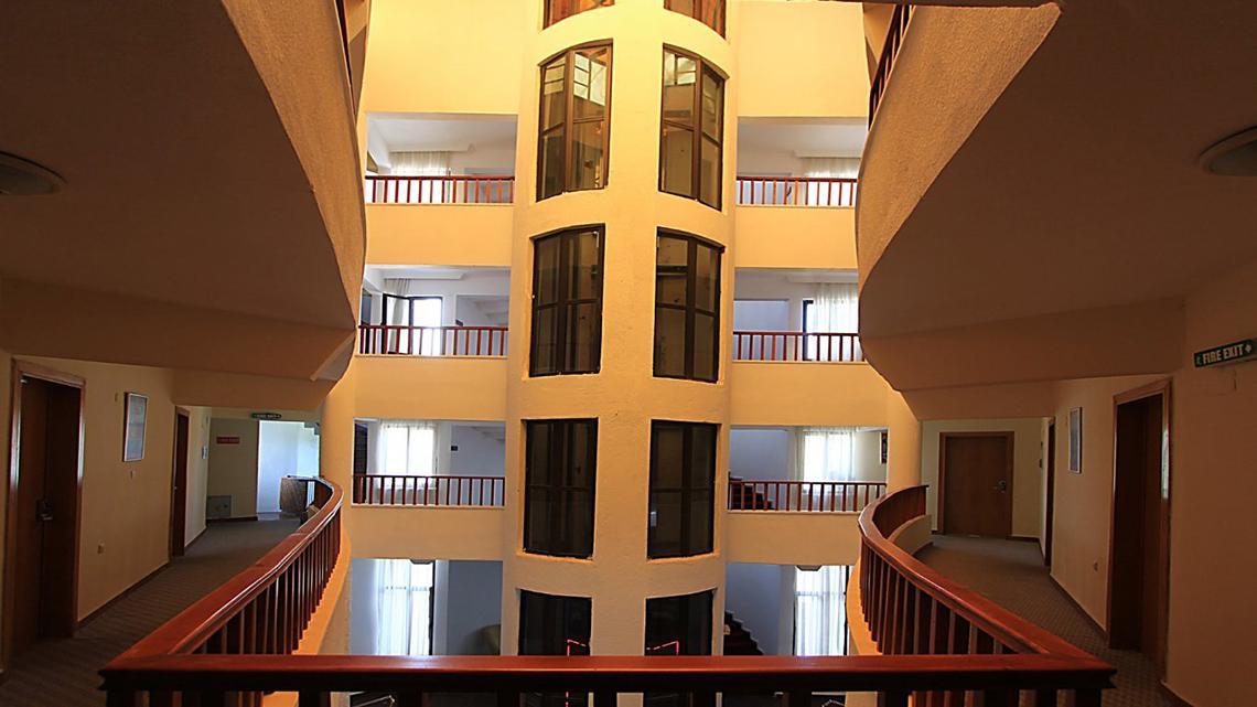 Innenansicht des Treppenhauses im Malhun Hotel mit mehreren Stockwerken, Balkons und Fenstern.
