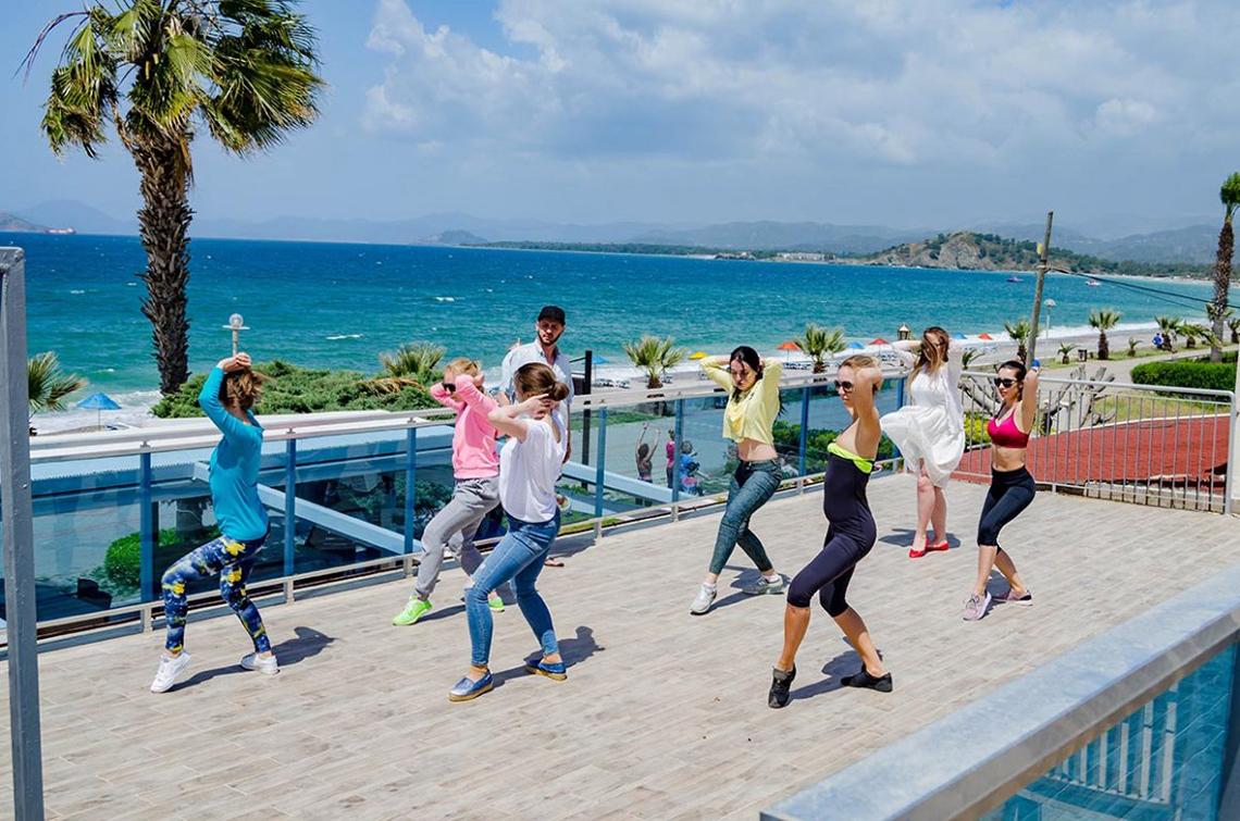 Gruppe von Frauen und Männern, die Aerobic auf der Dachterrasse des Malhun Hotels machen