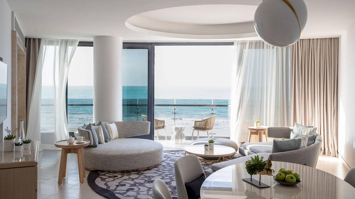 Wohnbereich des Jumeirah at Saadiyat Island Resort mit Meerblick, inklusive Sofa, Tisch und Balkon.