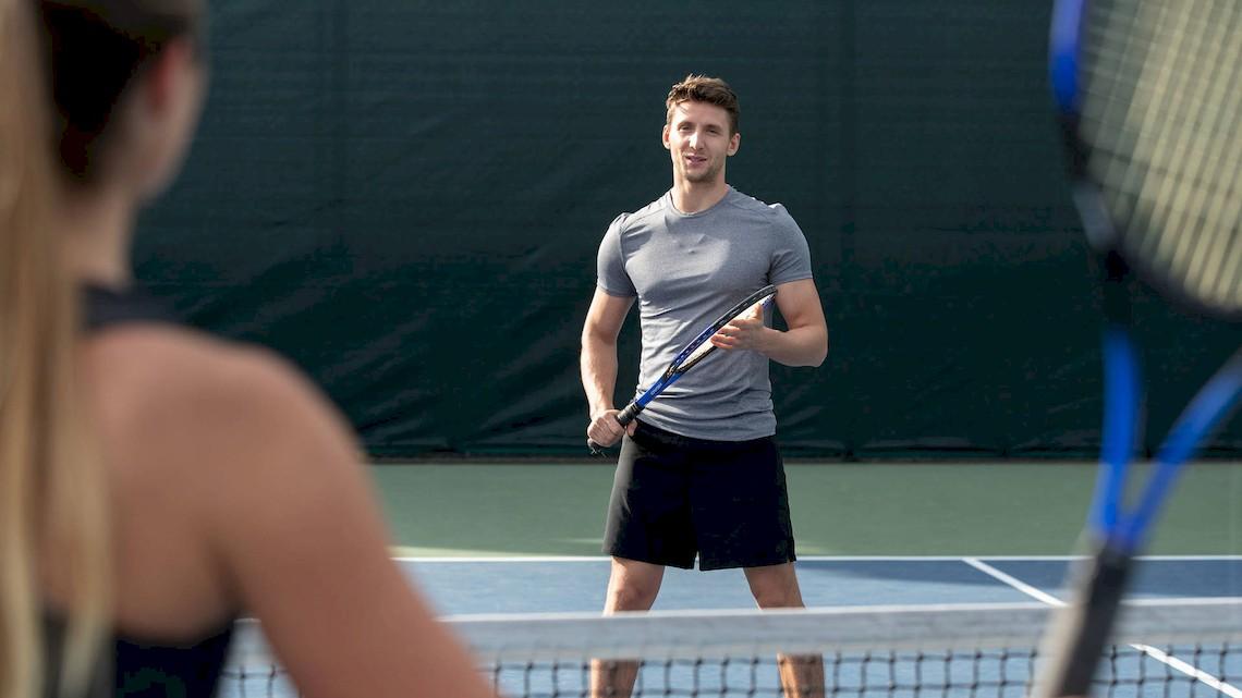 Tennisspieler im grauen T-Shirt und schwarzen Shorts auf einem Tennisplatz im Jumeirah at Saadiyat Island Resort