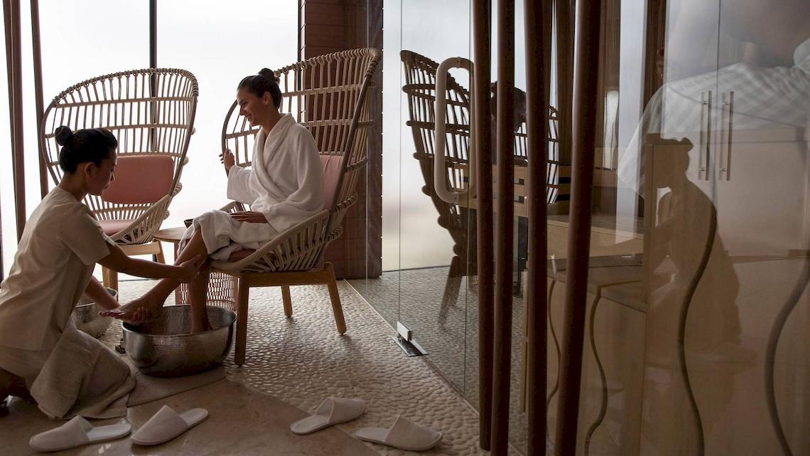 Spa-Behandlung im Jumeirah at Saadiyat Island Resort mit einer Frau, die sich die Füße waschen lässt.