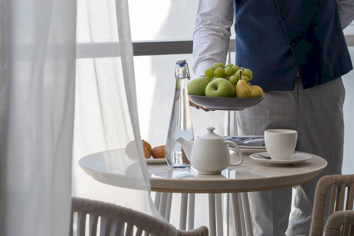 Ein Frühstückstisch im Jumeirah at Saadiyat Island Resort mit Obst, Teekanne und Tasse.