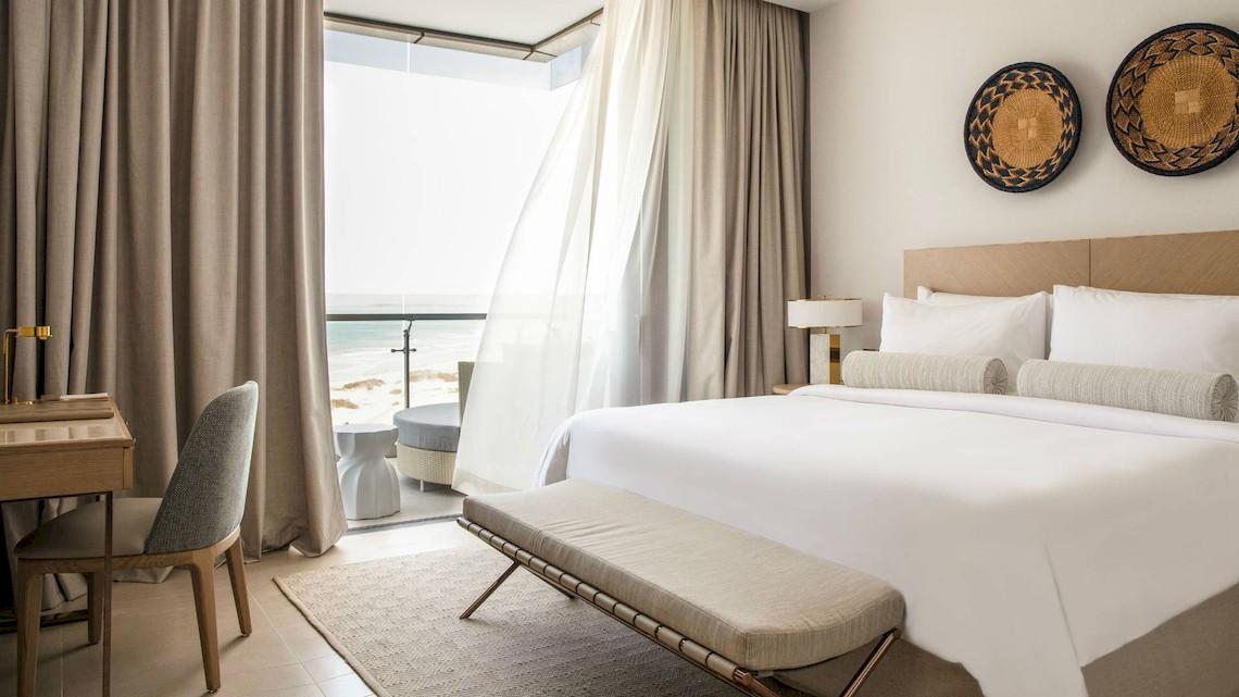 Innenansicht eines Schlafzimmers im Jumeirah at Saadiyat Island Resort mit Blick auf das Meer.
