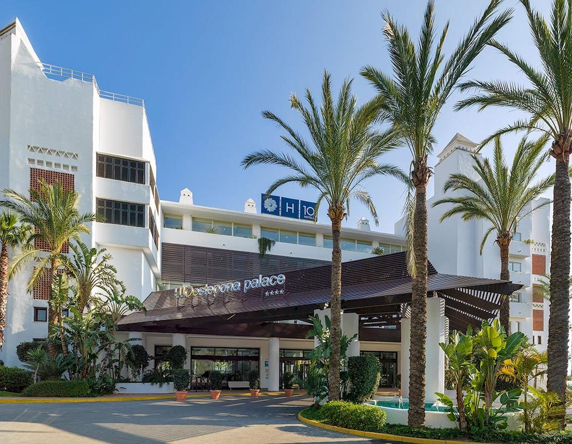 Foto des Eingangsbereichs des H10 Estepona Palace Hotels mit Palmen und Brunnen.