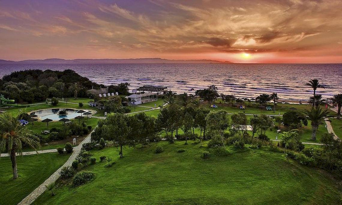 Luftaufnahme des Robinson Kyllini Beach Hotels mit Pool und Meer bei Sonnenuntergang
