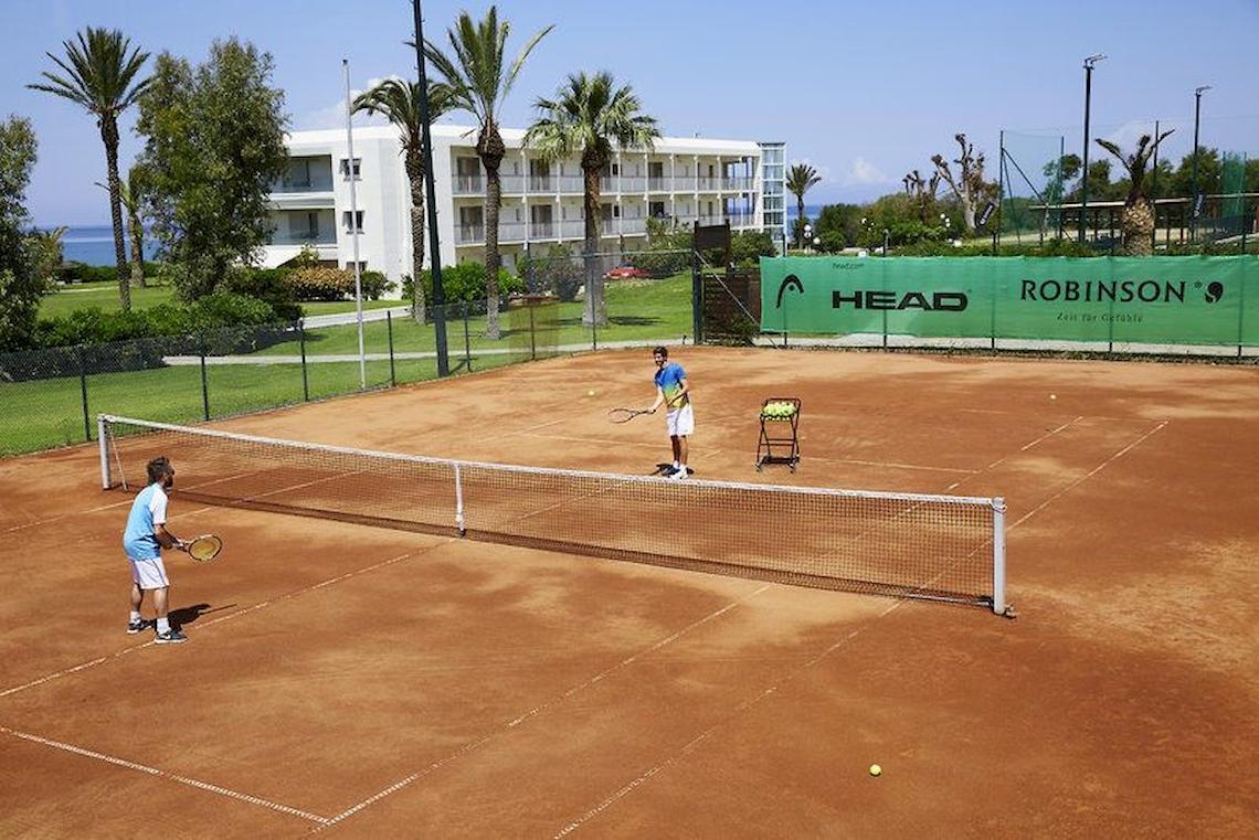 Tennisplatz im Robinson Kyllini Beach Hotel mit zwei Spielern und einem Trainer.