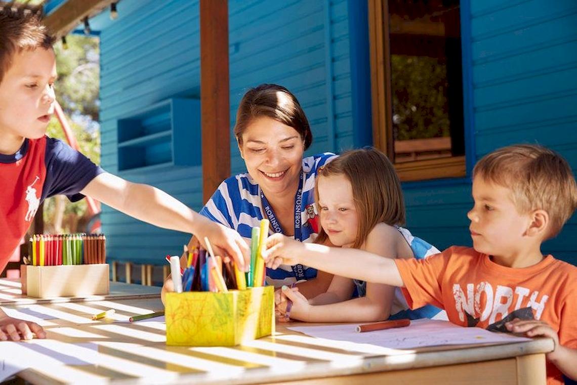 Frau mit Kindern am Tisch im Freien im Robinson Kyllini Beach Hotel