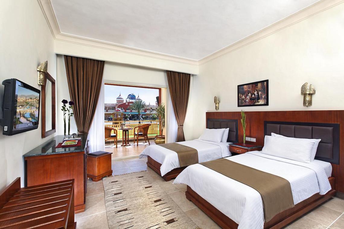 Doppelzimmer im Pickalbatros Aqua Blu Resort mit zwei Betten, Blick auf Terrasse und Garten.