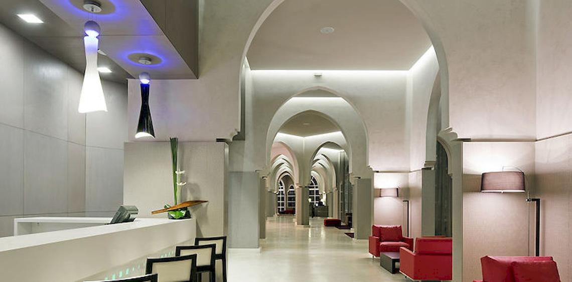 Empfangsbereich des Barcelo Palmeraie Hotels mit roten Sesseln und moderner Architektur.