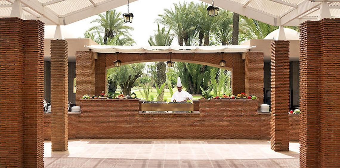 Ein Koch bereitet Speisen in einem Gartenbereich des Barcelo Palmeraie Hotels zu.