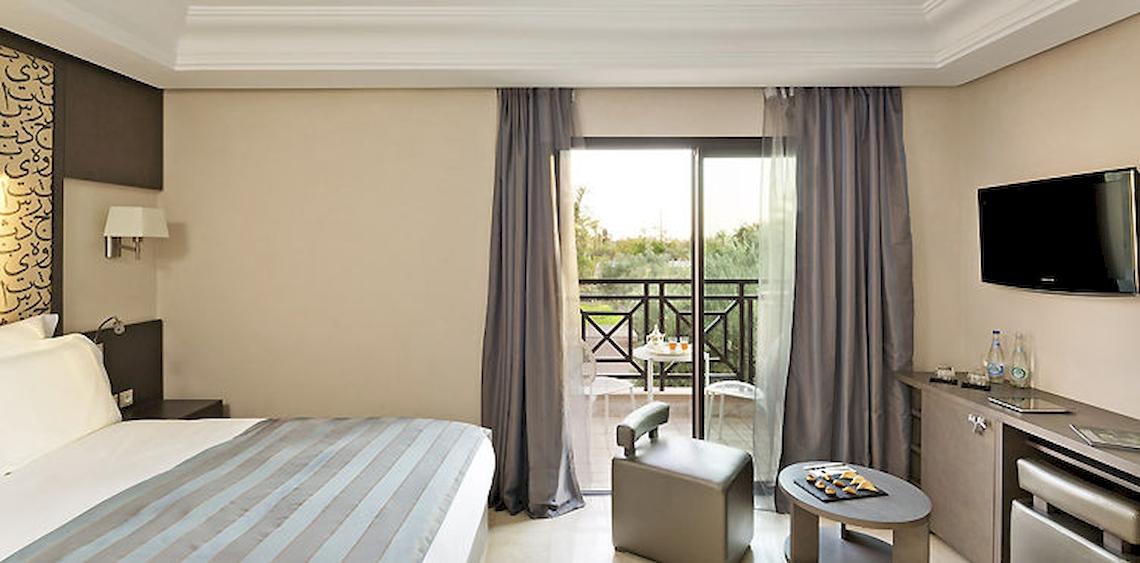Hotelzimmer im Barcelo Palmeraie Hotel mit Balkon und Ausblick auf den Garten.