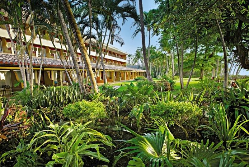 Außenansicht des Tamarindo Diria Beach Resorts mit grünen Pflanzen und Palmen