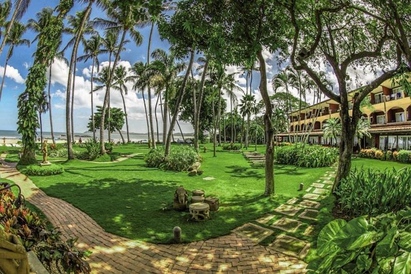 Gartenbereich des Tamarindo Diria Beach Resort mit gepflasterten Wegen und grüner Rasenfläche.