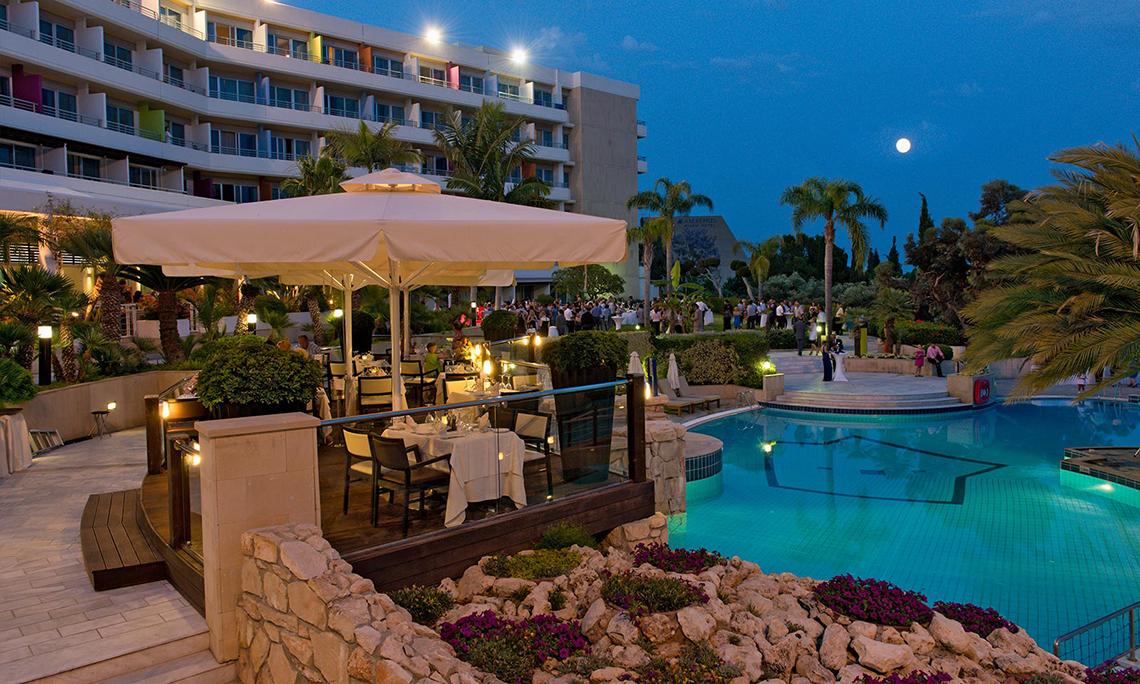 Gartengrill-Terrasse des Mittelmeer-Strandhotels in Zypern bei Nacht mit einem vollen Mond.