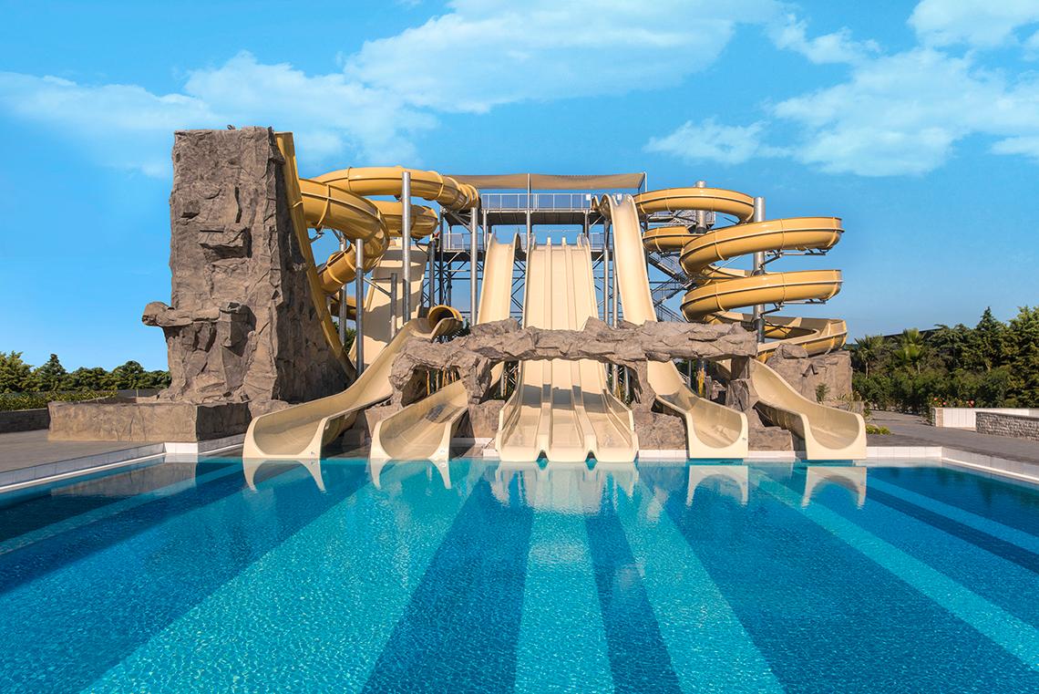 Wasserrutschen im Aska Lara Resort & Spa mit Pool und blauem Himmel