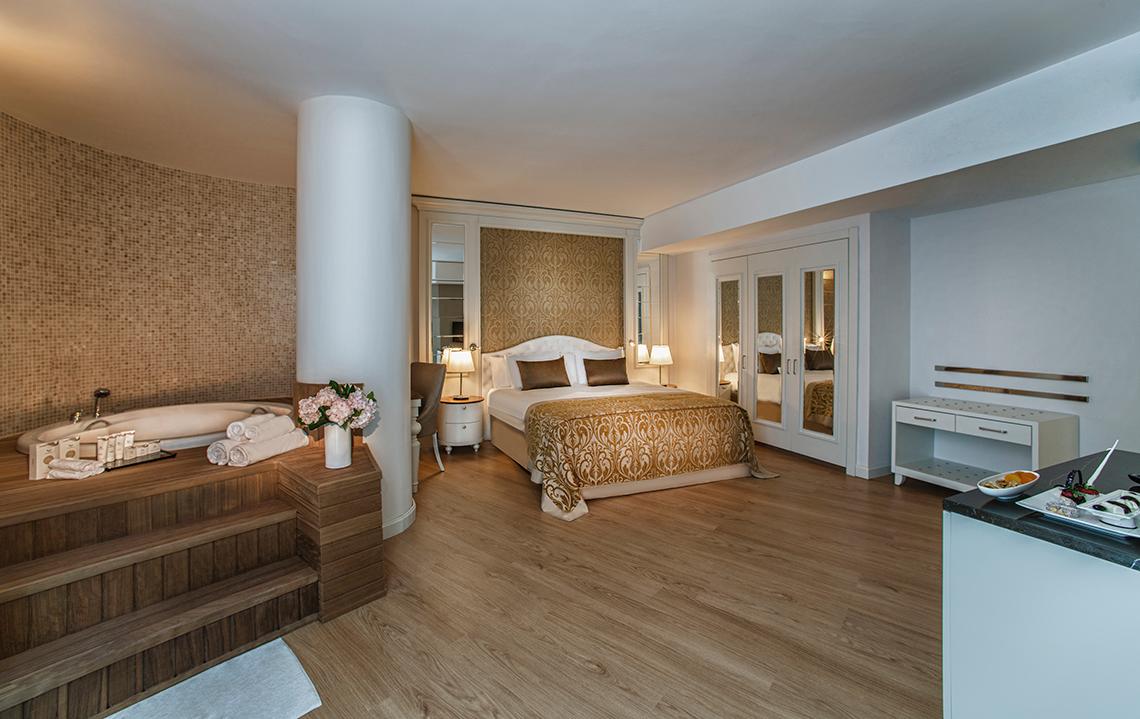 Hotelzimmer im Aska Lara Resort & Spa mit Bett, Badewanne und Essbereich.