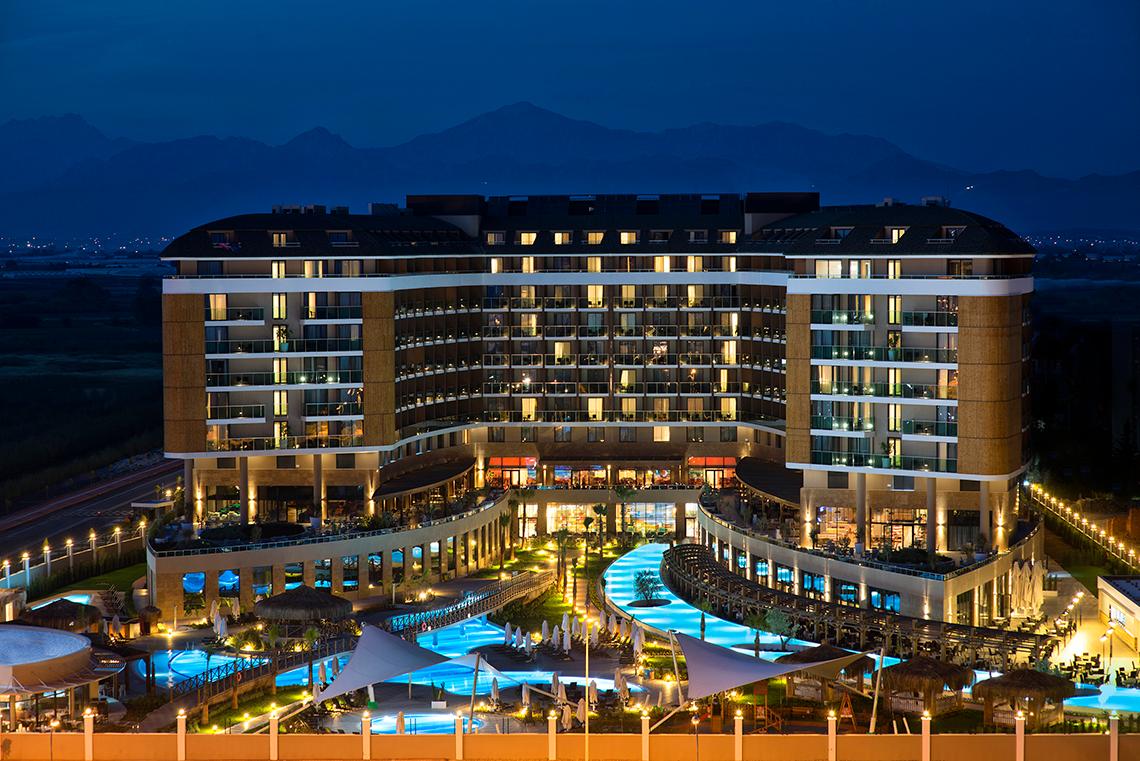 Aska Lara Resort & Spa bei Nacht mit beleuchteten Swimmingpools und Hotelgebäuden