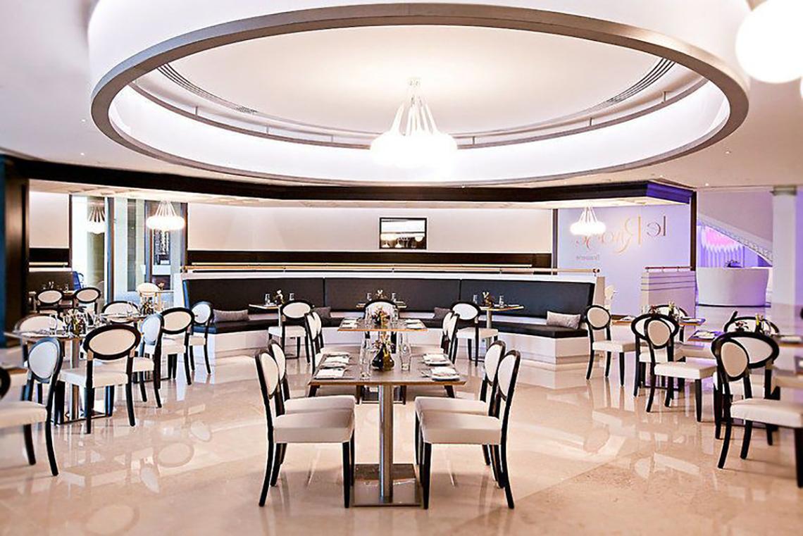 JA Ocean View Hotel Innenbereich mit runden Deckenleuchte und Sitzplätzen.