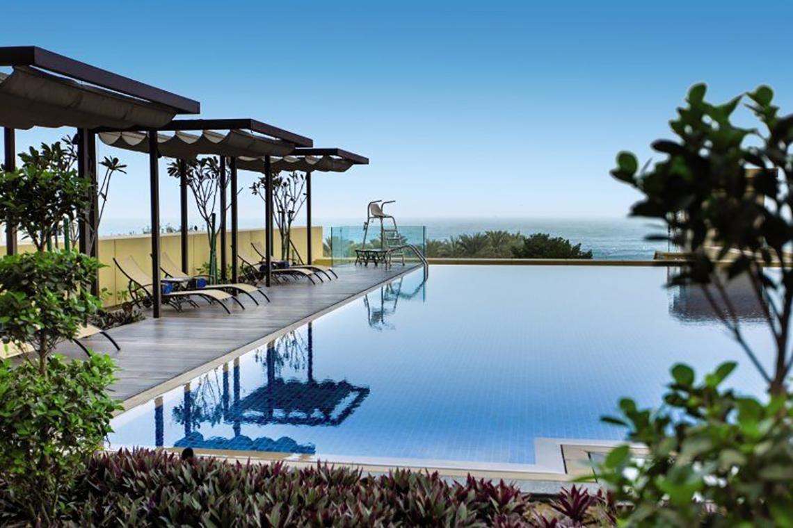 Dachpool im JA Ocean View Hotel mit Meerblick, Sonnenliegen und Überdachungen.