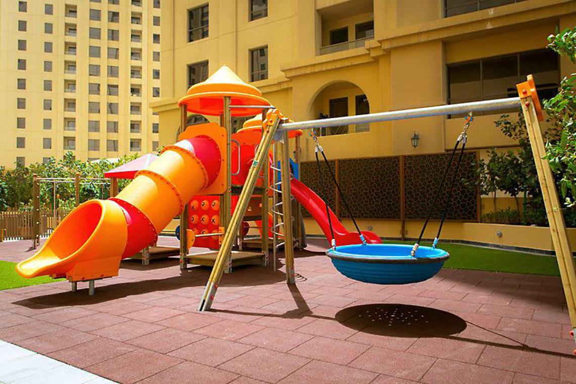 Spielplatz im JA Ocean View Hotel mit Rutsche und Schaukeln.