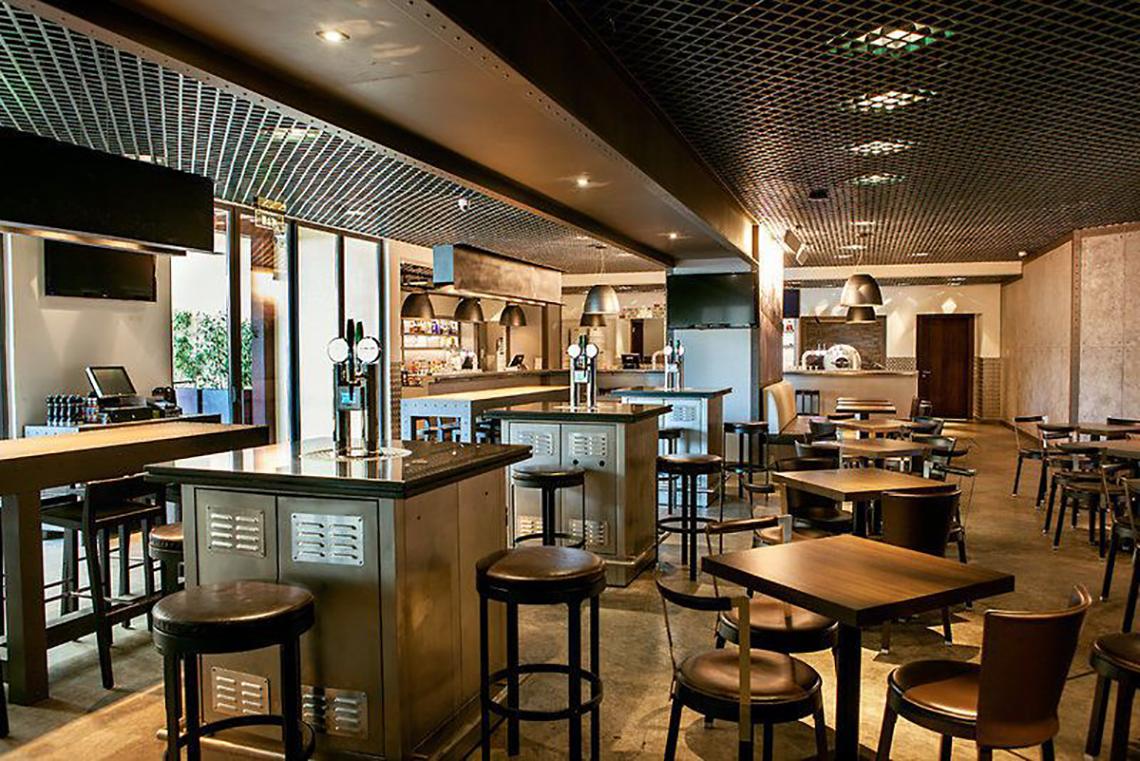 Innenbereich des JA Ocean View Hotels mit Bar, Tischen und Stühlen.