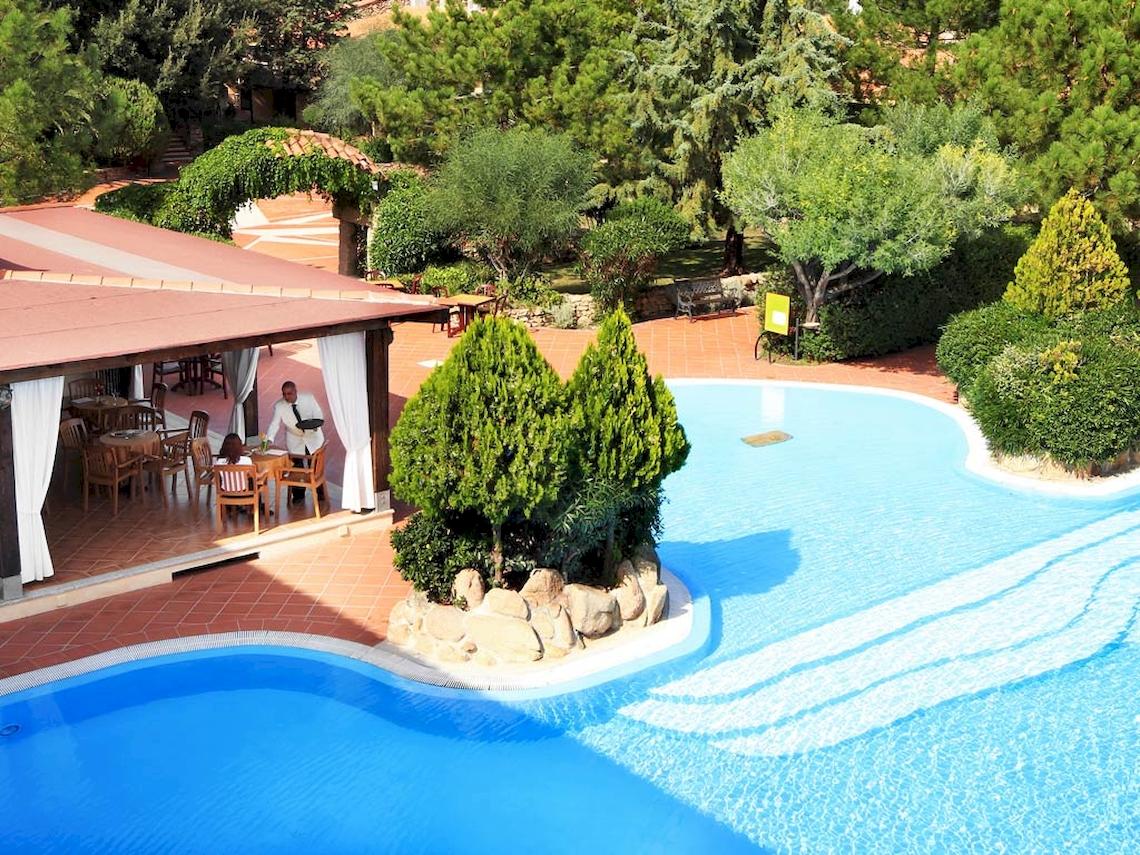Außenbereich des Pools im Colonna Hotel Du Golf mit Gästen und Bäumen