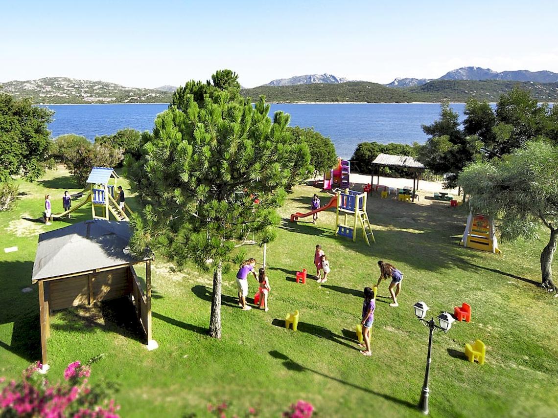 Aussicht auf den Spielplatz im Colonna Hotel Du Golf mit Kindern, die auf einer Wiese spielen.