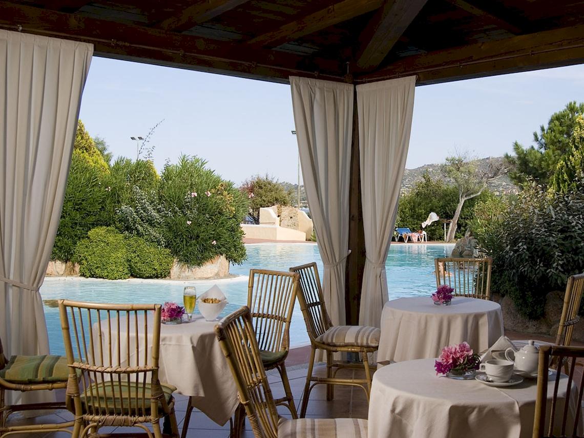 Terrasse im Colonna Hotel Du Golf mit Tischen und Stühlen, Blick auf den Pool