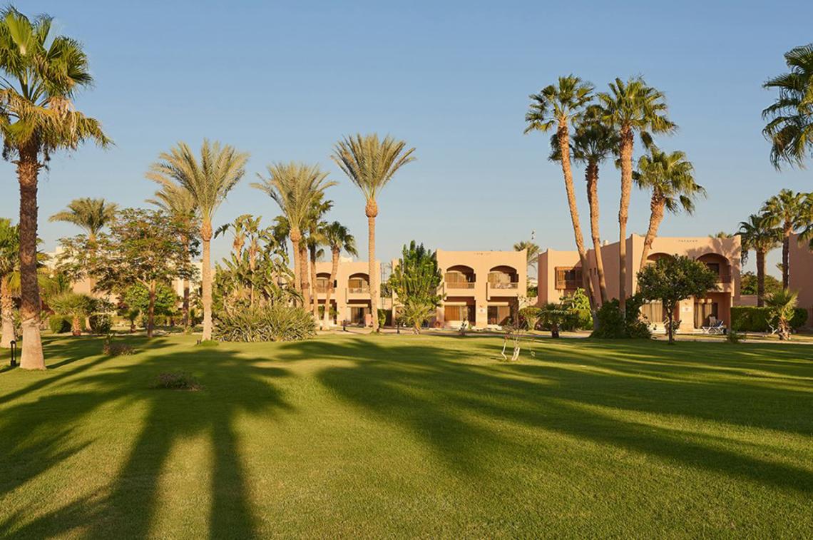 Außenbereich des Continental Hotel Hurghada mit Rasen und Palmen