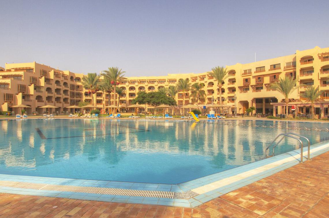 Außenpool des Continental Hotel Hurghada mit gelben Gebäuden und Palmen