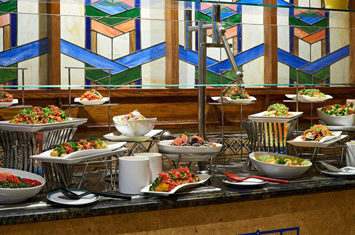 Buffet-Tisch im Continental Hotel Hurghada mit verschiedenen Gerichten auf weißen Tellern und Schalen.
