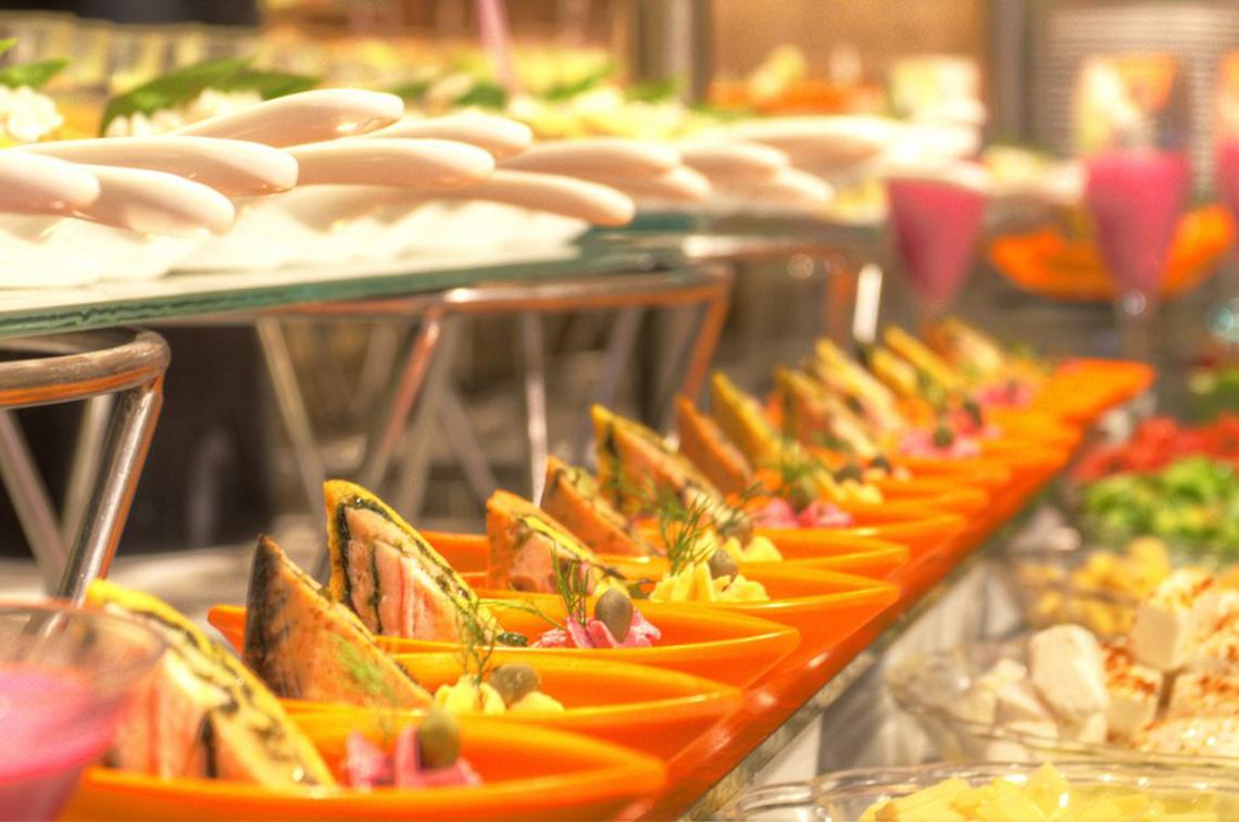 Buffet im Continental Hotel Hurghada mit verschiedenen Gerichten in orangefarbenen Schalen.