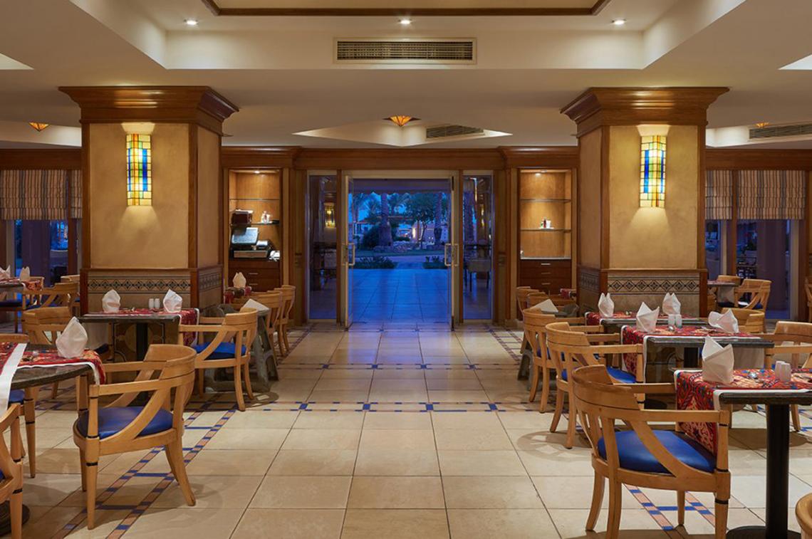 Innenansicht des Restaurants im Continental Hotel Hurghada mit gefliestem Boden und blauen Stühlen.
