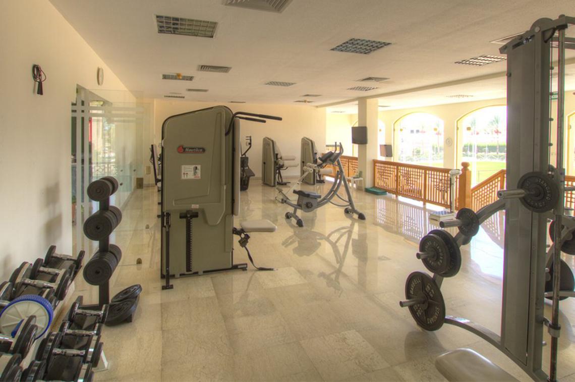 Fitnessraum im Continental Hotel Hurghada mit verschiedenen Trainingsgeräten und einer großen Fensterfront.